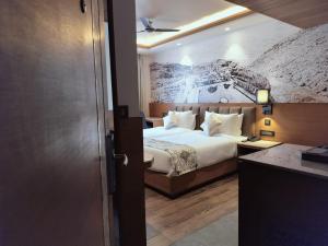 斋浦尔Hotel Royal Lakshmi Palace的一间卧室配有一张壁画床
