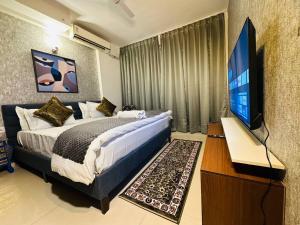 勒克瑙Celestial Chic Suite With Swimming Pool的一间卧室配有一张床和一台平面电视