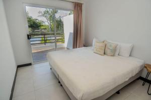 雅科Villa Paraiso do Mar的一间卧室设有一张床和一个大窗户