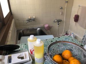 岛田農家民宿　佐京園的厨房柜台配有水槽和一碗橙子