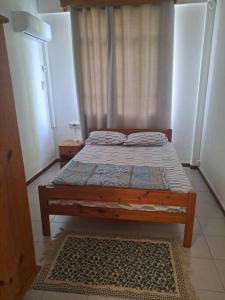 蓝海湾Le Residence Blue Bay的一间卧室配有一张带窗帘和地毯的床
