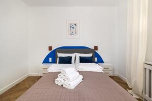 华沙ECRU Design Apartment in City Center WWA46的卧室配有蓝色和白色的床,提供毛巾