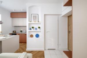 华沙ECRU Design Apartment in City Center WWA46的厨房配有白色橱柜和白色门