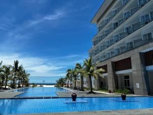 洞海Duy Tân Quảng Bình Hotel & Resort的大楼旁的大型游泳池