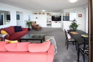 黄金海岸布罗德沃特海岸海滨公寓的客厅配有红色的沙发和桌子