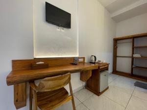 塞莱马德加巴利安天堂酒店的客房设有一张木桌,墙上配有电视。