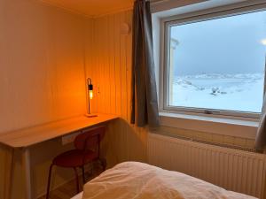 伊卢利萨特Grand seaview vacation house, Ilulissat的卧室设有窗户,床边设有椅子