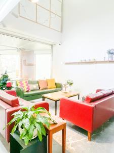 大邱Empathy Guesthouse的客厅配有红色和绿色的沙发