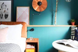 安特卫普安特卫普市中心英迪格酒店的一间卧室设有蓝色的墙壁、一张床和一个时钟