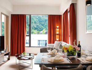 香港Eaton Residences, Blue Pool Road的一间带餐桌的客厅和一间带红色窗帘的客厅