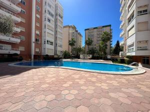 Puerto de GandíaLas Olas 400m playa con WiFi AC y piscina的一座游泳池,位于部分建筑的中间