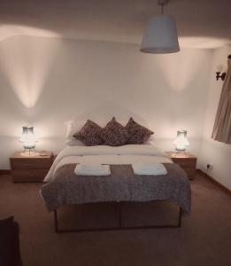 Mossleythe lodge@ beechwood house的一间卧室配有一张大床和两盏灯