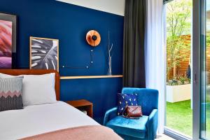 安特卫普安特卫普市中心英迪格酒店的一间卧室设有一张床和蓝色的墙壁