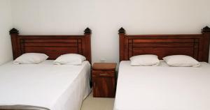 马特莱Geeth Lanka River Resort的两张睡床彼此相邻,位于一个房间里