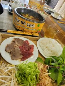 Vị ThanhKhách sạn Hậu Giang的餐桌,饭盘和汤碗