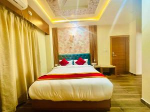 拜拉哈瓦Hotel Ultra International的一间卧室配有一张带红色枕头的大床