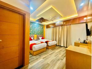 拜拉哈瓦Hotel Ultra International的酒店客房带两张床和一间浴室