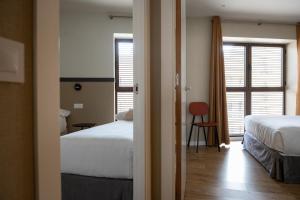 巴塞罗那MH城市公寓酒店的酒店客房设有两张床和窗户。