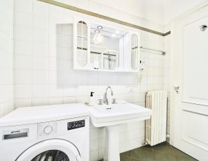 米兰Navigli Elyon apartment的白色的浴室设有洗衣机和水槽。