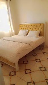 ThikaSerene Safaris Airbnb in Thika的卧室内的一张带床头板和枕头的床