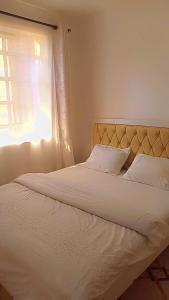ThikaSerene Safaris Airbnb in Thika的卧室配有白色的床和窗户