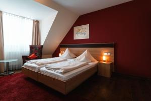 维森布伦施瓦泽尔阿德勒兰德酒店的一间卧室设有一张红色墙壁的大床