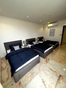 吉达Luxurious Apartment Partial Sea View的一间设有两张床的卧室,铺有大理石地板。