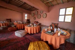 MhamidErg Chegaga Desert Standard Camp的一间用餐室,在房间内配有两张桌子