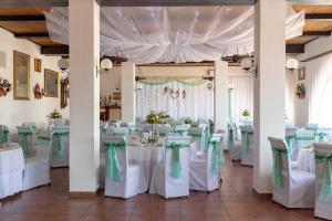 尼赖吉哈佐Kemence Csárda és Szálloda的宴会厅配有白色桌子和绿色椅子