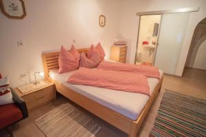 Penznhof的一间卧室配有带橙色床单和镜子的床