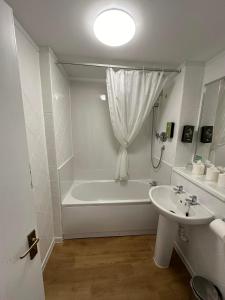 温德米尔温德米尔酒店的白色的浴室设有浴缸和水槽。