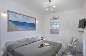帕诺尔莫斯米科诺斯Panormos Beach Escape Dreamy Coastal Retreat的一间卧室,配有一张床,上面放着一碗水果