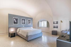 克雷莫纳Foresteria Il Voltone的一间卧室设有一张大床和一个窗户。