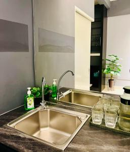丹绒亚路M Suite Homestay, Aeropod Sovo Kota Kinabalu的厨房柜台设有水槽和镜子