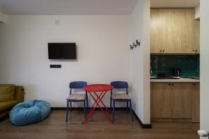 古多里Marshall Gudauri Stylish Apartment By Wehost的客厅配有红色的桌子和两把椅子