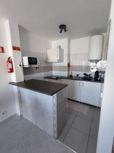 奎特里拉Alsol C 5361-1的厨房配有白色橱柜和黑色台面