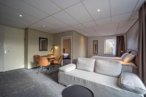 泽赫瑟弗莱彻酒店的酒店客房配有床、沙发和桌子。