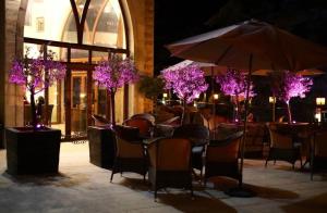 代埃尔卡马尔L'auberge des Emirs的一间设有桌椅和紫色树木的餐厅
