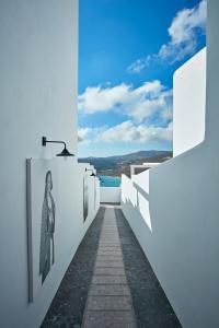 埃利亚海滩Myconian Avaton, a Member of Design Hotels的白色墙壁走廊,享有水景