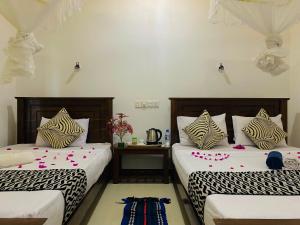 锡吉里亚Lucky Villa Sigiriya的一间卧室配有两张鲜花床。