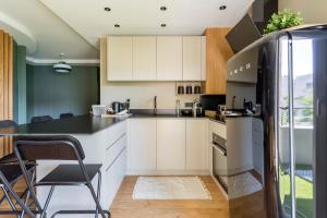里昂Appartement spacieux avec balcon 6pers的厨房配有白色橱柜和黑色台面