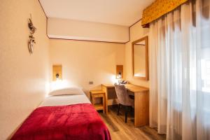 瓦托内切比久酒店的配有一张床、一张书桌和一扇窗户的酒店客房