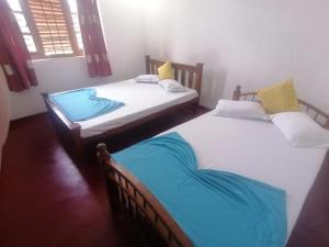 波隆纳鲁沃Sunshine Guest House的客房内的两张单人床