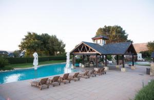 帕尔Pearl Valley Golf lodge的一个带椅子的游泳池和一个带喷泉的凉亭