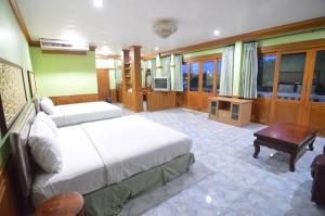 甘烹碧泰克诺江景度假酒店的一间卧室配有两张床和电视。