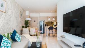 邦涛海滩Cassia Residences的客厅配有白色沙发和电视