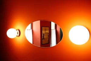 库塔伊西Hotel Memoire Kutaisi的墙上的镜子,上面有灯