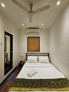 孟买藏红花酒店的一间卧室配有一张带吊扇的床