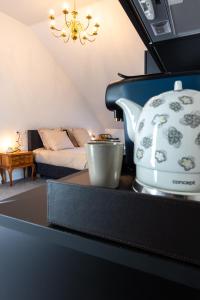 马尔什昂法梅讷Li Ter Hôtel的茶壶坐在房间里的一个柜台上