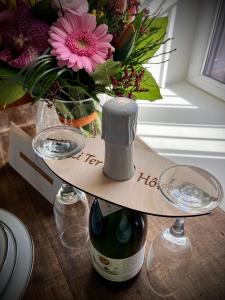 马尔什昂法梅讷Li Ter Hôtel的一瓶葡萄酒和一瓶花在桌子上